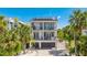 Stunning three-story home featuring a rooftop deck, balconies, and lush landscaping at 4101 4Th Ave, Holmes Beach, FL 34217