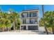 Two story coastal home boasts a modern design, multiple balconies, a gray garage door, and well-maintained landscaping at 4101 4Th Ave, Holmes Beach, FL 34217