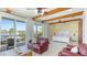Bright main bedroom features wood beam ceilings, balcony access and comfortable sitting area at 4101 4Th Ave, Holmes Beach, FL 34217