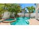 Sparkling pool and jacuzzi surrounded by lush landscaping with a tranquil waterfall create a private backyard oasis at 4101 4Th Ave, Holmes Beach, FL 34217