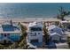 Aerial view of beachfront homes by the ocean with a sailboat nearby at 412 S Casey Key Rd, Nokomis, FL 34275