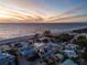 Aerial view of beachfront homes near the ocean with stunning sunset background at 412 S Casey Key Rd, Nokomis, FL 34275