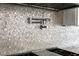 Unique backsplash detail with stainless steel faucet fixture above gas range at 412 S Casey Key Rd, Nokomis, FL 34275