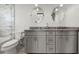 Well lit bathroom features dual sinks with gray vanity, stone countertops and round mirrors at 412 S Casey Key Rd, Nokomis, FL 34275