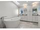 A modern bathroom with a soaking tub, double sinks, and chandelier lighting at 412 S Casey Key Rd, Nokomis, FL 34275