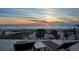 An oceanfront patio with lounge furniture offers a view of a sandy beach and a beautiful sunset at 412 S Casey Key Rd, Nokomis, FL 34275