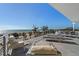 An oceanfront patio with lounge furniture overlooks a sandy beach and ocean views at 412 S Casey Key Rd, Nokomis, FL 34275