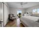 Bedroom with neutral decor including a ceiling fan, tile floors, and a chair near a window at 412 S Casey Key Rd, Nokomis, FL 34275