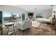 Bright bedroom with a seating area, fireplace, and sliding doors to a beachfront patio with ocean view at 412 S Casey Key Rd, Nokomis, FL 34275