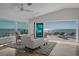 A cozy seating area sits in the bedroom with views of the ocean and a slider to the outdoor patio at 412 S Casey Key Rd, Nokomis, FL 34275