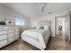 Bright bedroom boasts a ceiling fan, tile floors, and a white dresser with framed art at 412 S Casey Key Rd, Nokomis, FL 34275