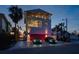 Three-story home with balconies, a two-car garage, and lush landscaping at 412 S Casey Key Rd, Nokomis, FL 34275
