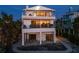 Modern house with multiple decks and balconies at dusk at 412 S Casey Key Rd, Nokomis, FL 34275