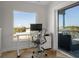 A bright home office with a modern desk, large window, and access to a balcony at 412 S Casey Key Rd, Nokomis, FL 34275