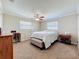 Comfortable bedroom features neutral tones, carpet, ceiling fan, and natural light at 4120 Shamrock Dr, Venice, FL 34293