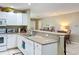 Open concept kitchen features white cabinets, granite countertops, and seating bar area at 4120 Shamrock Dr, Venice, FL 34293