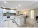 Bright kitchen features white cabinetry, granite countertops, and tile flooring, open to living area at 4120 Shamrock Dr, Venice, FL 34293