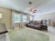 Spacious living room with tile flooring, ceiling fan, and large windows overlooking the yard at 4120 Shamrock Dr, Venice, FL 34293