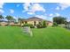 Expansive backyard with lush green lawn, palm trees, and view of the community at 4331 Turnberry Cir, North Port, FL 34288