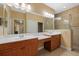 Bathroom with a vanity, dual sinks, a separate water closet, a walk-in closet, and a tiled shower with glass doors at 4331 Turnberry Cir, North Port, FL 34288