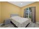 Bedroom featuring a ceiling fan, large window, hardwood floors, and a gray bed frame with a patterned mattress set at 4331 Turnberry Cir, North Port, FL 34288