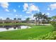 Beautiful view of the pond surrounded by lush green lawns and swaying palm trees at 4331 Turnberry Cir, North Port, FL 34288