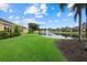 Scenic view of the pond with fountain, lush lawn, and tropical landscaping at 4331 Turnberry Cir, North Port, FL 34288