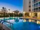 Community pool with night lighting, palm trees, and chairs at 435 S Gulfstream Ave # 601, Sarasota, FL 34236