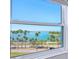 Stunning water view from a window overlooking palm trees, sailboats, and the bay at 435 S Gulfstream Ave # 601, Sarasota, FL 34236