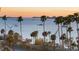 Stunning waterfront view with palm trees and boats on the horizon during a colorful sunrise at 435 S Gulfstream Ave # 601, Sarasota, FL 34236