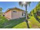 Home exterior featuring well-maintained landscaping, a palm tree, and privacy bushes at 4406 Turnberry Ct, Bradenton, FL 34210