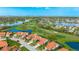 Aerial view of a home on a golf course with a pond, mature trees, and lush landscaping at 4909 Clubview E Ct, Bradenton, FL 34203
