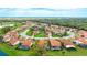 Aerial view of a home on a golf course with a mature tree and lush landscaping at 4909 Clubview E Ct, Bradenton, FL 34203