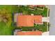 Overhead view of home with an orange tile roof, enclosed patio, lush lawn, and tropical landscaping at 4909 Clubview E Ct, Bradenton, FL 34203