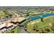 Aerial view of the community, golf course, pool, and clubhouse surrounded by lush landscaping and waterways at 4909 Clubview E Ct, Bradenton, FL 34203