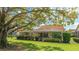 Backyard featuring lush lawn, mature tree, and screened lanai perfect for outdoor living at 4909 Clubview E Ct, Bradenton, FL 34203