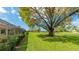 Backyard view features mature trees and a lush green golf course beyond the hedge at 4909 Clubview E Ct, Bradenton, FL 34203