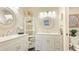 Bright bathroom featuring double vanities, round mirrors, and neutral decor at 4909 Clubview E Ct, Bradenton, FL 34203