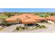 Exterior view of the clubhouse with a circular driveway, fountain, and beautiful landscaping at 4909 Clubview E Ct, Bradenton, FL 34203