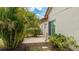 Exterior view of home with tropical landscaping and a paved side patio at 4909 Clubview E Ct, Bradenton, FL 34203