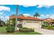 Inviting home featuring a tile roof, a two-car garage, well-maintained landscaping and a neatly manicured lawn at 4909 Clubview E Ct, Bradenton, FL 34203