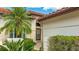 Charming home featuring lush landscaping, a tile roof, and a welcoming front entrance with a decorative window above the door at 4909 Clubview E Ct, Bradenton, FL 34203