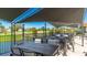 Outdoor seating area with tables and chairs overlooking the golf course and pond at 4909 Clubview E Ct, Bradenton, FL 34203