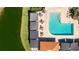 Aerial view of a swimming pool, lounge chairs, and tables next to a pond at 4909 Clubview E Ct, Bradenton, FL 34203