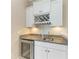 Wet bar area features granite countertops, wine rack, beverage fridge, and white cabinetry at 5602 Tidewater Preserve Blvd, Bradenton, FL 34208