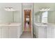 Bathroom view featuring double vanities and a hallway leading to a bedroom at 5602 Tidewater Preserve Blvd, Bradenton, FL 34208
