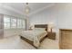 Bright bedroom with tray ceiling, paneled wall, wood floors, and natural light from large windows at 5602 Tidewater Preserve Blvd, Bradenton, FL 34208