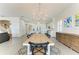 Dining room featuring a large wooden table and seating for six guests, with views of the living room and modern kitchen at 5602 Tidewater Preserve Blvd, Bradenton, FL 34208