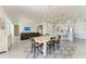 Dining room featuring a large wooden table and seating for six guests, with views of the living room and modern kitchen at 5602 Tidewater Preserve Blvd, Bradenton, FL 34208