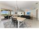 Dining room featuring a large wooden table and seating for six guests, with views of the living room and outdoor pool at 5602 Tidewater Preserve Blvd, Bradenton, FL 34208
